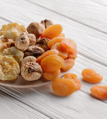 mixed-dried-fruits-on-white-plate-on-wooden-table-VQV5ED2